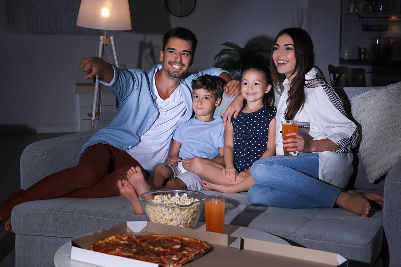 Happy,Family,Watching,Tv,On,Sofa,At,Night